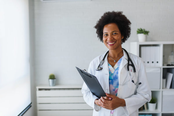 Portrait of female African American doctor standing in her offic