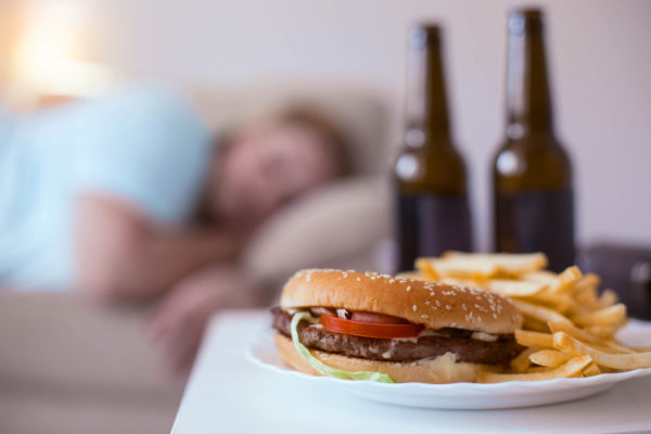 Junk food. Greasy nasty hamburger with fries lying on a plate